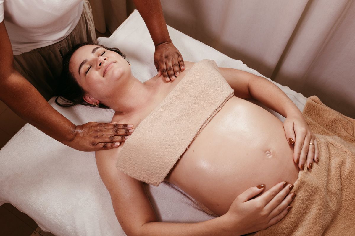 Pregnant woman receiving prenatal massage at spa, relaxing shoulder and chest therapy for maternity wellness